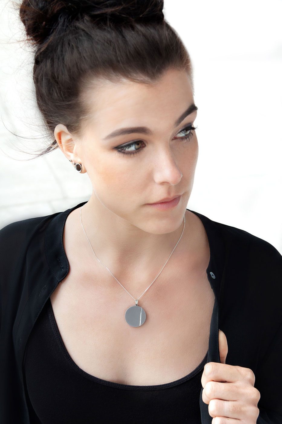 Betonschmuck aus der Studio 4L Manufaktur, echte Statements in Grau und Silber. Der Anhänger R1 strahlt an einer filigraner Schlangenkette.