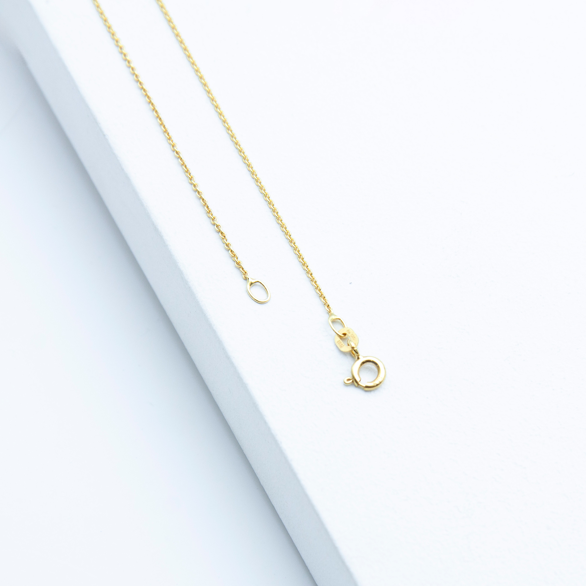 Detailfoto einer Ankerkette aus 585er Gelbgold von Studio 4L, 45 cm lang, 1,1 mm stark, mit Federringverschluss.