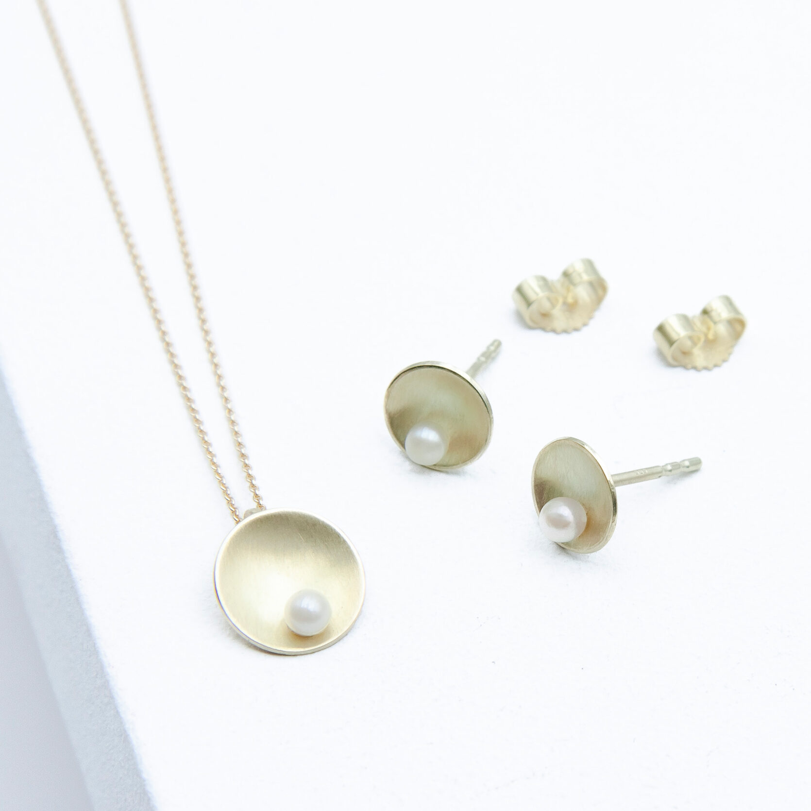 Schmuckset Shell Gold Akoya aus 585er Gelbgold mit weißer Akoya-Perle, runder mattierter Anhänger, 10 mm Durchmesser und 8mm Ohrstecker Shell Gold Akoya.